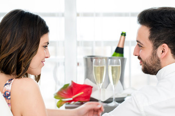 Side view of couple with sparkling wine in background.