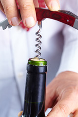 man opening a bottle of wine