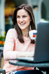 Young brunette woman sitting at a coffeeshop and relaxing