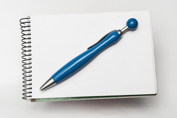 blue pen on notebook on white background
