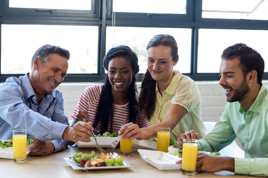 Colleagues having breakfast in office
