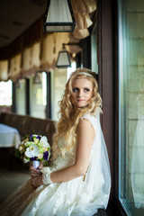 elegant stylish groom with his happy gorgeous blonde bride in th