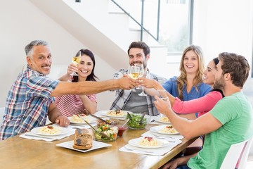 Friends toasting wine glasses while having a meal