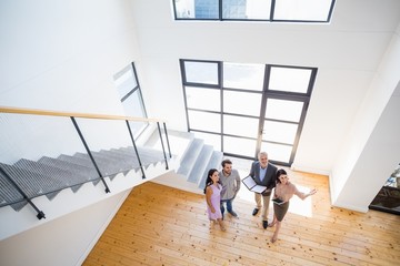 Real estate agent showing new house to couple - Powered by Adobe