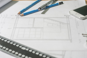 Architectural blueprints and blueprint rolls and a drawing instruments on architects desk