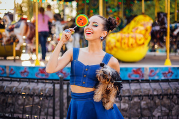 Bright makeup beautiful girl with Yorkshire Terrier holding watermelon lollipop.