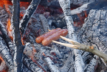 Grilling sausage at a bonfire