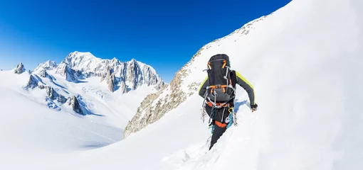 Foto op Aluminium Bergbeklimmer beklimt een besneeuwde top. Op de achtergrond de gletsjers en de top van de Mont Blanc, de hoogste Europese berg. De Alpen, Chamonix, Frankrijk, Europa. © rcaucino