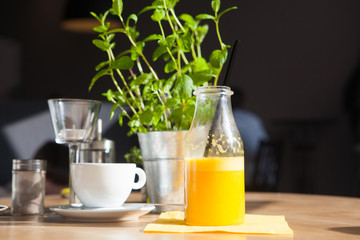 Bottle of Freshly squeezed orange juice sitting on a rustic wooden table.