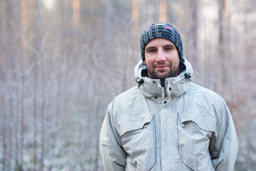 Fototapeta na wymiar Positive man in warm clothing outdoors on winter day 