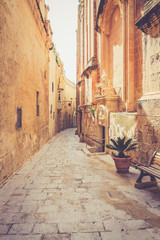 Naklejka premium Ancient narrow street in Mdina, Malta. Warm color filter used