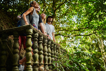 Naklejka na ściany i meble group of tourists exploring ancient jungle ruins in thailand