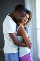 Naklejka premium Young couple embracing near window