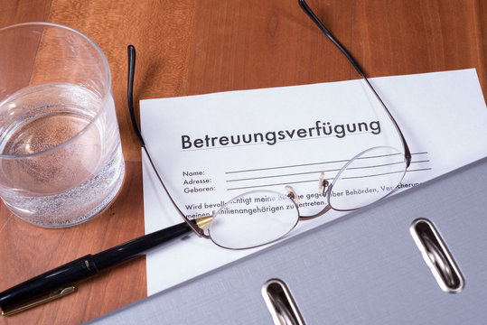 Betreuungsverfügung mit Brille, Füller und Ordner