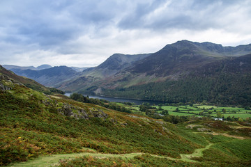 Fototapeta na wymiar Climbing Rannerdale Knotts, Lake District National Park, UK. Buttermere to Rannerdale walk with views over Buttermere Village, Lake Buttermere