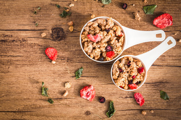 Homemade granola with dried berries on a wooden background