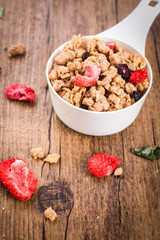 Homemade granola with dried berries on a wooden background