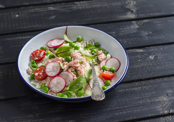 Fresh salad with cous cous, vegetables and baked salmon. Healthy tasty food. On a dark wooden background
