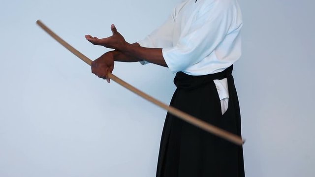 Martial arts Master in black hakama practice martial arts with wooden jo stick on white background