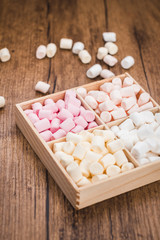 Box with marshmallows on the wooden background