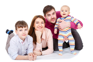 Young father and mather hugs childrens and baby boys lying on the floor - Concept of happy family. Isolated on white background