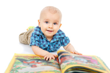 Smart little baby boy in shirt reading a book on the floor, isolated on white background