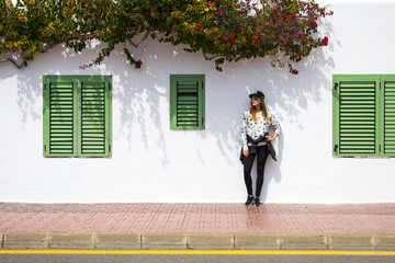 Young girl standing against classic spanish building facade with coloured shutters