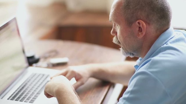 Senior man works with laptop