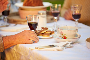 Hand mit Glas Wein am Tisch