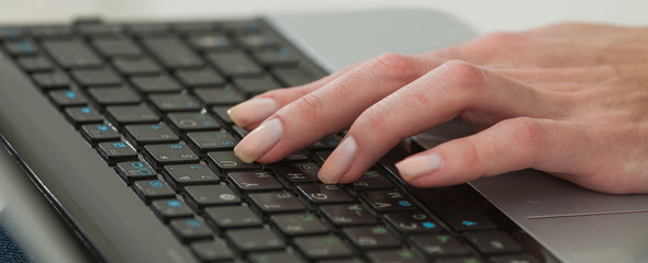 Female hands against the laptop keyboard