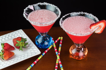 Strawberry margarita cocktail garnished with salt rim and slice of strawberry.