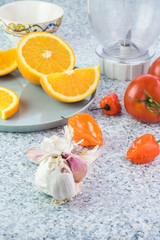 Ingredients for chili sauce. Orange, tomatoes, garlic, chili peppers.