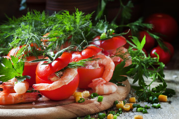 Tomatoes stuffed with shrimp meat and corn on a wooden plate, se