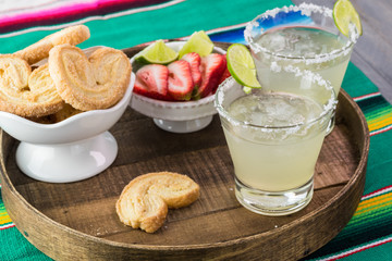 Classic margarita cocktail garnished with salt rim,  lime wheel.