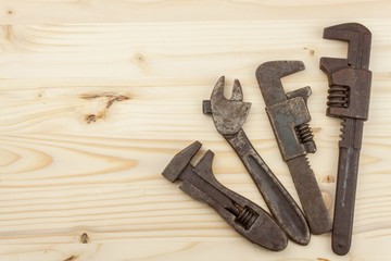 Old rusty mechanics tools on a wooden background. Advertising for new tools. Sales tools. Place for your text.
