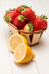 Strawberries in a small basket and lemon