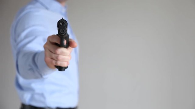 Businessman holding a pistol, closeup shot