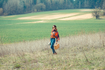 Beautiful hipster girl in a beret makes movies on vintage movie camera. modern girl travels to wildlife with vintage camera