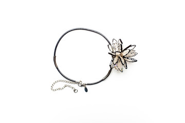 Necklace on black cord and a decorative flower