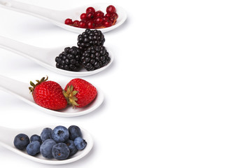 Different berries in the spoons