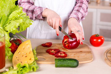 woman slicing pepper on woden board