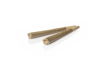Two medical cannabis rolled joints on white background from side