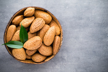 Group of almond nuts with leaves.Wooden background.