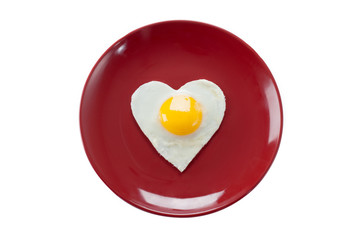 fried egg in heart shape served in a plate.
