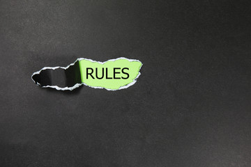 rules written under black torn paper
