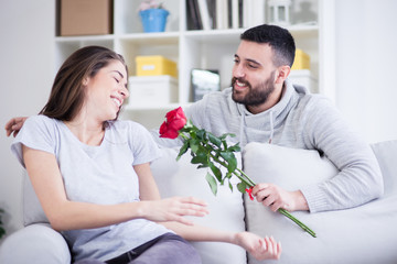 Young man giving a red rose to his girlfriend