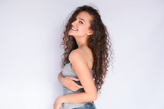 Happy Smiling Young Woman With Curly Hair Look From The Back