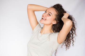 Naklejka premium Beautiful portrait of young brunette woman flirt with curly hair and a tongue