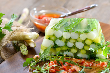 Veganes Spargelgelee mit weißem und grünem Spargel in pflanzlichem Gelee mit Paprika-Vinaigrette serviert - Vegetable jelly with fresh white and green asparagus, served with red pepper vinaigrette