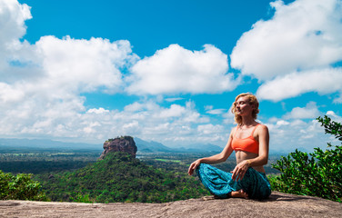 Naklejka na ściany i meble Young woman meditation on the mountain Pidurangala Rock, Sri Lanka. Sigiriya